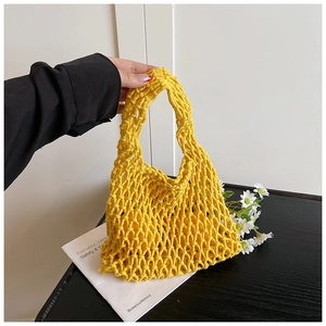 Détail d'un sac en maille évidée jaune vif tissé à la main avec motifs en losanges