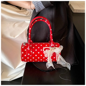 Polka dot cylinder handbag with pearl charms and lace bow in a lifestyle setting