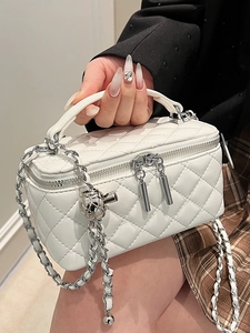 White quilted crossbody vanity bag with silver chain strap and top handle style