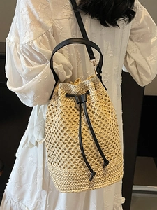 Chic hollow woven bucket bag with drawstring closure and leather handles for beach vacation