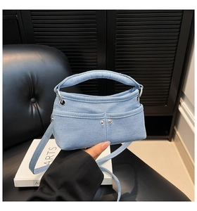 Dettaglio mini borsa in denim azzurro con rivetti argentati e tracolla sottile