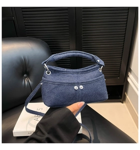 Vista dettagliata della mini borsa in denim blu con rivetti argentati e dettagli in metallo
