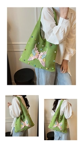 Detail view of woven green tote bag featuring colorful beads and a 3D butterfly applique