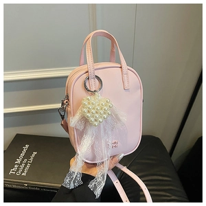 Dettaglio della borsa a tracolla in pelle rosa con ciondolo cuore di perle e pizzo