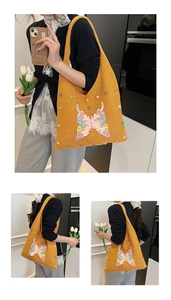 Detailed knit texture and colorful pearl beads on butterfly embroidery of yellow tote bag