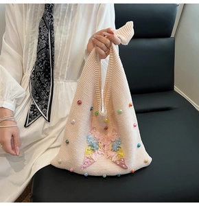 Detailed close-up of woven bag with colorful 3D butterfly embroidery and pearl beads