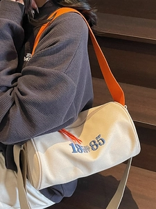 Chic off-white barrel tote bag with vibrant orange strap and vintage 1985 embroidery