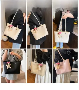 Detail of minimalist tote bags in beige, black and pink with cute plush dog pendants