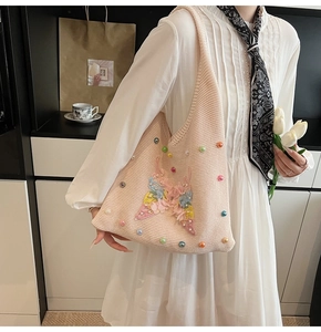 Detailed embroidery of colorful butterflies and pearls on the pink knit shoulder bag