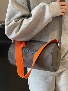 Chic dark grey canvas barrel tote bag with bright orange strap and vintage embroidery