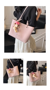Pink lychee grain leather tote bag with unique knotted strap and cute puppy plush charm