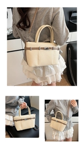 Détail du sac seau crème avec lanières marron et fermoir pivotant en métal raffiné