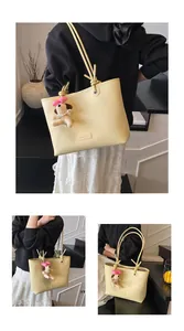 Detail of light yellow lychee pattern tote bag with cute plush puppy charm accessory