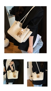 Detail of cream lychee texture tote bag with a cute bear charm and thin straps