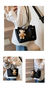 Close-up of black lychee grain leather tote bag featuring a cute fashion bear charm