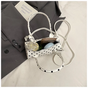 Close-up of small polka dot pillow bag showing interior storage for makeup and perfume