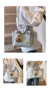 Detail of light blue lychee pattern tote bag featuring cute teddy bear charm pendant