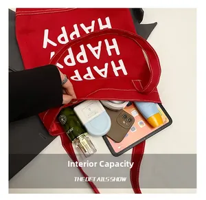 Internal capacity of red canvas tote bag showing space for tablet and cosmetics