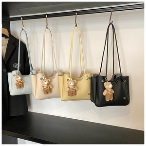 Detail of lychee textured leather tote bags in blue, white, yellow, and black colors