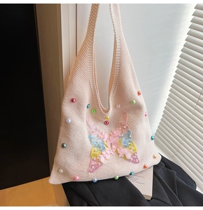 Detail of crochet knit handbag with colorful 3D butterfly applique and pastel beads