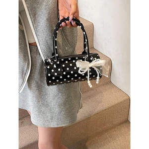 French style polka dot cylinder handbag with white ribbon and pearl charm on stairs