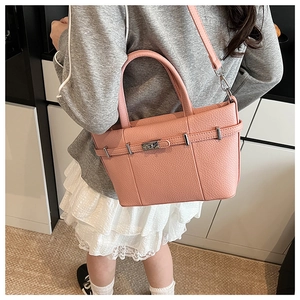 Détail d'un sac seau en cuir rose avec fermoir argenté et bandoulière réglable