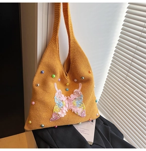 Detailed close-up of yellow knit tote with colorful beads and 3D butterfly patch