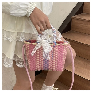 Détail du panier tressé rose avec un nœud en dentelle blanche et anse en ruban