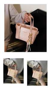 Close-up of pink bucket bag with gold hooks and 'FASHION & BAGS' lettering detail