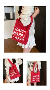 Detail of red canvas tote bag with Happy Happy Happy print for casual daily commuting