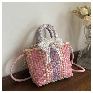 Détail du sac à main tressé rose et bleu avec un grand nœud en dentelle blanche élégant