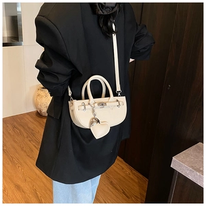 Chic off-white lychee grain half-moon crossbody bag shown on model in modern setting
