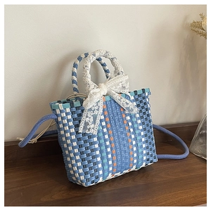 Vue détaillée du sac cabas tissé avec un élégant nœud décoratif en dentelle blanche