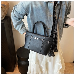 Détails du sac seau en cuir grainé noir avec fermoir rotatif argenté et bandoulière