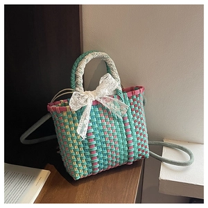 Vue détaillée du sac à main tissé avec rayures colorées, nœud en dentelle et sangle
