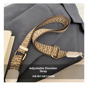 Détail de la bandoulière tissée réglable avec motifs géométriques et boucles bronze