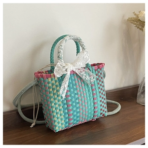 Détail du sac tissé multicolore avec un nœud en dentelle blanche et une doublure intérieure