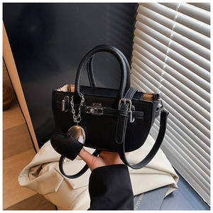Close-up of black lychee grain leather handbag with silver buckle and heart charm