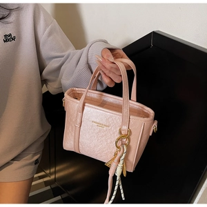 Detailed macro view of pink wrinkled texture mini tote bag with gold metal buckle