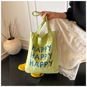 Detailed stitching on lime green canvas tote bag featuring blue HAPPY letter prints