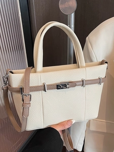 Sac seau chic en cuir grainé blanc cassé avec lanière marron et fermoir rotatif argenté