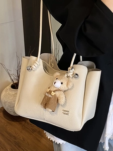 Chic beige lychee grain leather tote bag for women with a cute plush bear pendant accessory