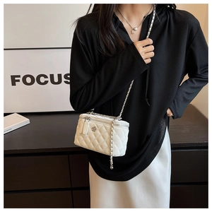 Detail view of white quilted crossbody bag with silver camellia floral metal decor
