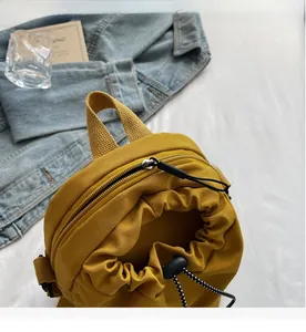 Detail view of mustard yellow canvas bag showing smooth zipper and drawstring closure system