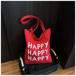 Detail of red canvas tote bag with Happy lettering stored in a felt organizer basket