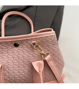 Close-up of pink woven texture with high-quality gold hardware and leather strap