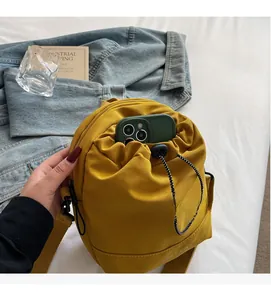 Close-up of yellow drawstring crossbody bag showing internal phone compartment space