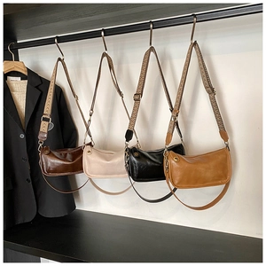 Détail de sacs demi-lune en quatre couleurs avec bandoulière tissée et sangle en cuir