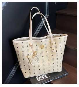 Detail of classic printed beige tote bag with bear pattern and golden metal plate