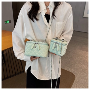 Close-up of mint green quilted chain bags in two sizes with floral zipper pulls